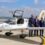 three men in front of the Halcón aircraft
