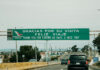 "Gracias por su visita, feliz viaje" reads a sign over a Mexican highway