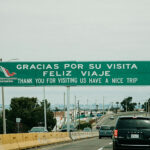 "Gracias por su visita, feliz viaje" reads a sign over a Mexican highway