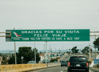 "Gracias por su visita, feliz viaje" reads a sign over a Mexican highway
