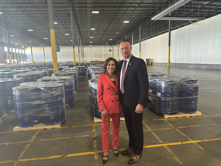 U.S. Attorney Jeanine Pirro stands with barrels of precursor chemicals in a Houston warehouse