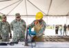 Soldiers destroying confiscated firearms with a machine
