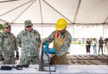 Soldiers destroying confiscated firearms with a machine