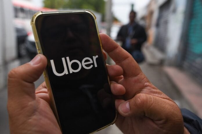 Anuncian aumento costos UBER Uber app in cell phone