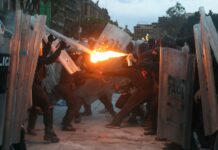 protster aiming fire at police