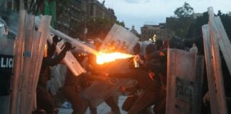 protster aiming fire at police