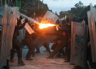 protster aiming fire at police