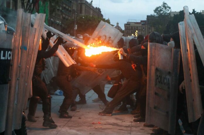 protster aiming fire at police