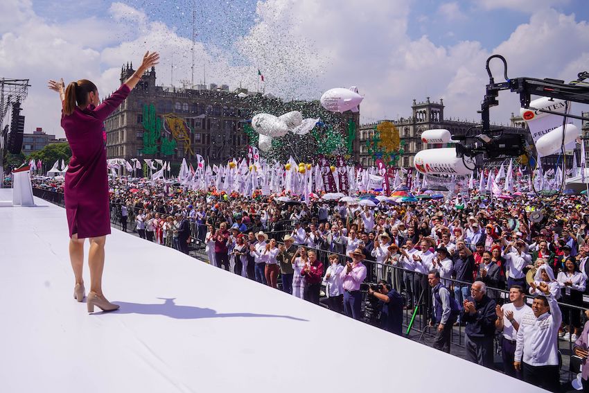 Sheinbaum extending her arms out to a crowd in Mexico City's Zócalo