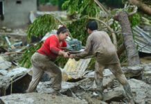 People offering each other help in a flood scenario