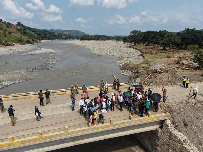 A group of politicians stand on a bridge about the Pantepec River in Veracruz