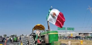 A farmer protesting corn prices in Mexico sits in his tractor during a blockade in León, Mexico