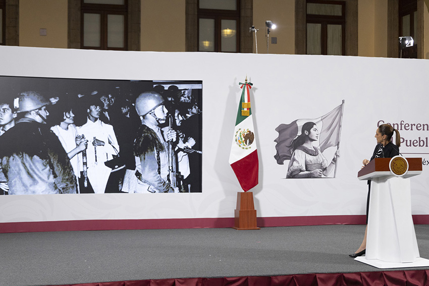 Sheinbaum looks at a photo of soldiers from the Tlatelolco massacre at her morning press conference