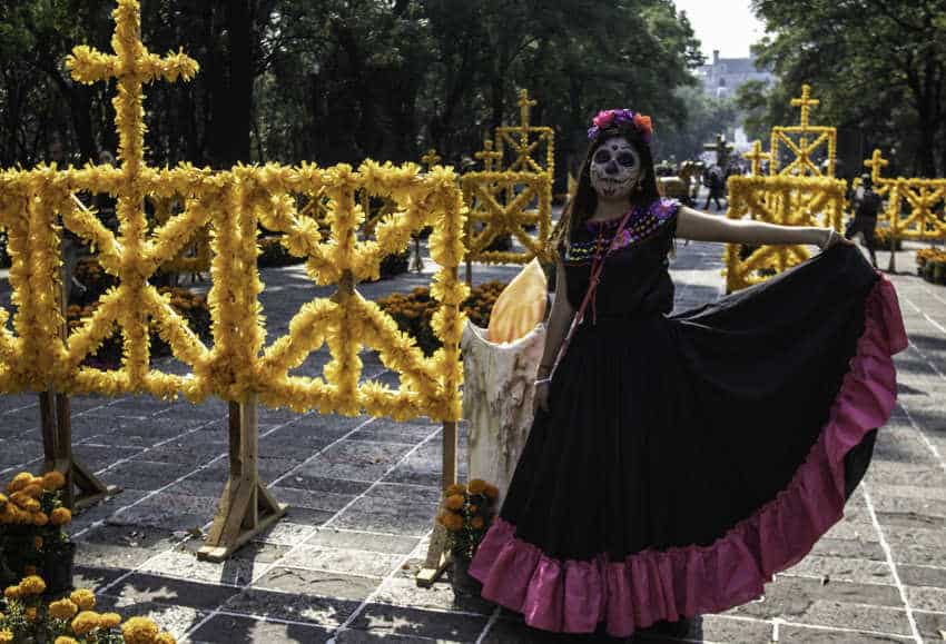 Woman successful  a accepted   Mexican people  formal  wearing a crown of flowers and a white-painted look   similar  a Catrina, emblematic  for Day of the Dead festivities successful  Mexico City successful  November.