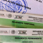 A close-up of two Mexican residency cards: a 'Residente Temporal' (Temporary Resident) card and a 'Residente Permanente' (Permanent Resident) card, on top of official INM immigration paperwork.
