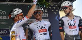 Teammates in cycling gear and helmets places a palm crown on Mexican cyclist Isaac del Toro