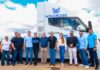 staff in front of electric transport vehicle