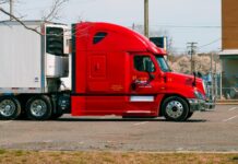 a side view of a red heavy duty truck