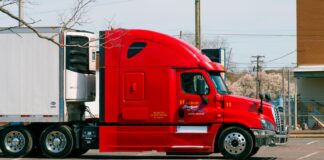 a side view of a red heavy duty truck