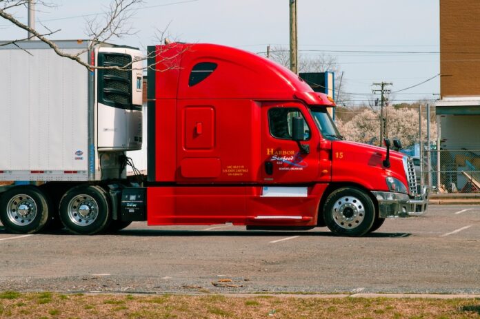 a side view of a red heavy duty truck
