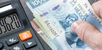 Stock image of a 500 Mexican peso bill next to a calculator