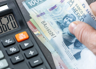 Stock image of a 500 Mexican peso bill next to a calculator