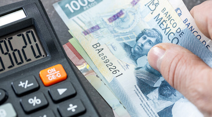 Stock image of a 500 Mexican peso bill next to a calculator
