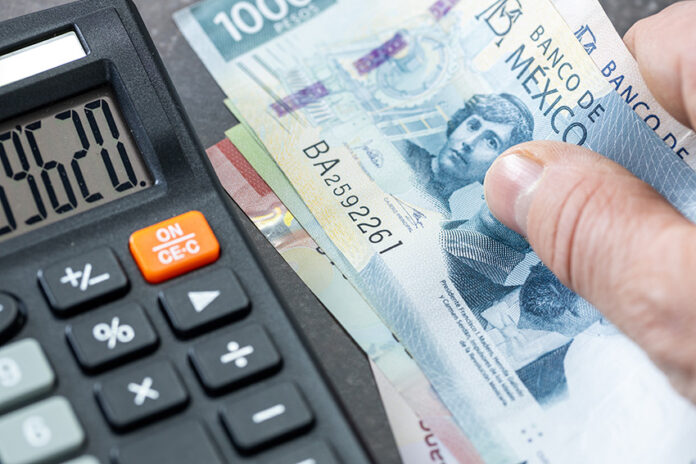 Stock image of a 500 Mexican peso bill next to a calculator