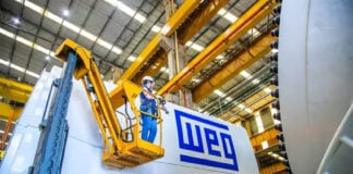 An engineer in a forklift next to a piece of machinery labeled WEG