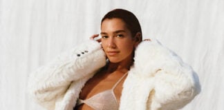 Dua lipa in a white fuzzy coat and shiny bikini top