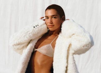 Dua lipa in a white fuzzy coat and shiny bikini top