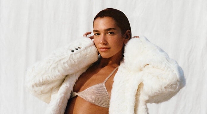 Dua lipa in a white fuzzy coat and shiny bikini top