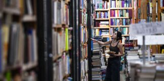 a girl looks at shelves in a book store
