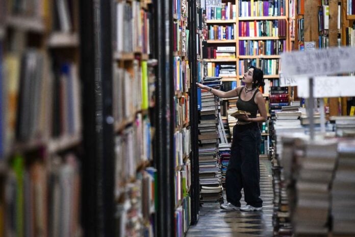 a girl looks at shelves in a book store