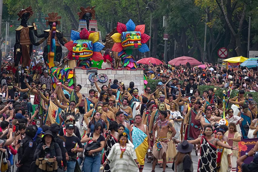 A parade with hundreds of people, some dressed in Indigenous costume