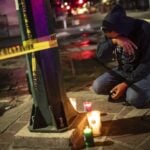 man kneeling with candles