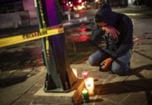 man kneeling with candles