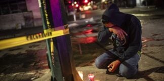 man kneeling with candles