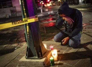 man kneeling with candles