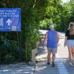 two people walking towards a beach in Tulum