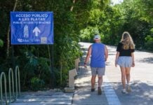 two people walking towards a beach in Tulum