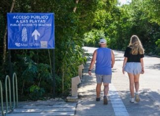 two people walking towards a beach in Tulum