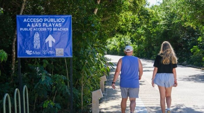 two people walking towards a beach in Tulum