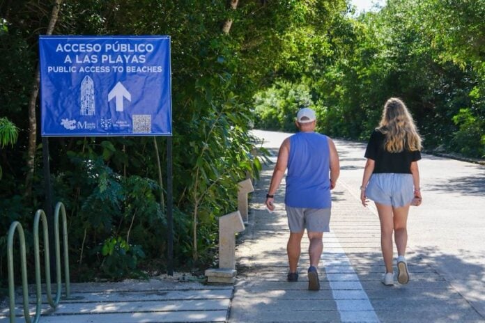two people walking towards a beach in Tulum