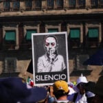 Protest sign with the word "SILENCIO" and a modified photo of Mexican President Claudia Sheinbaum on a poster at a "Generation X" protest near Mexico City's National Palace in November 2025, a sign of the political polarization currently heightening in Mexico.