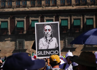 Protest sign with the word "SILENCIO" and a modified photo of Mexican President Claudia Sheinbaum on a poster at a "Generation X" protest near Mexico City's National Palace in November 2025, a sign of the political polarization currently heightening in Mexico.