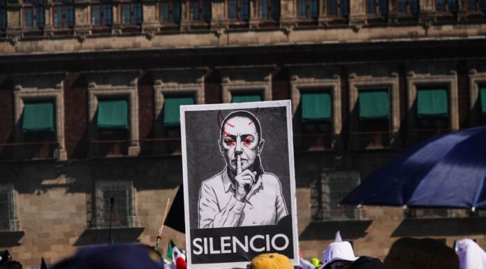 Protest sign with the word "SILENCIO" and a modified photo of Mexican President Claudia Sheinbaum on a poster at a "Generation X" protest near Mexico City's National Palace in November 2025, a sign of the political polarization currently heightening in Mexico.