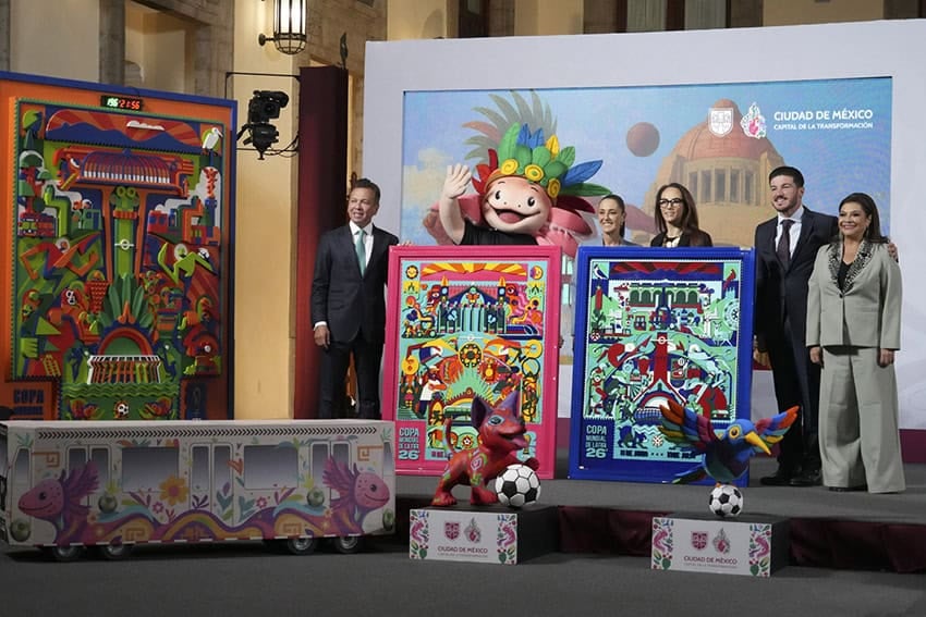 Government officials stand on a stage next to colorful World Cup posters