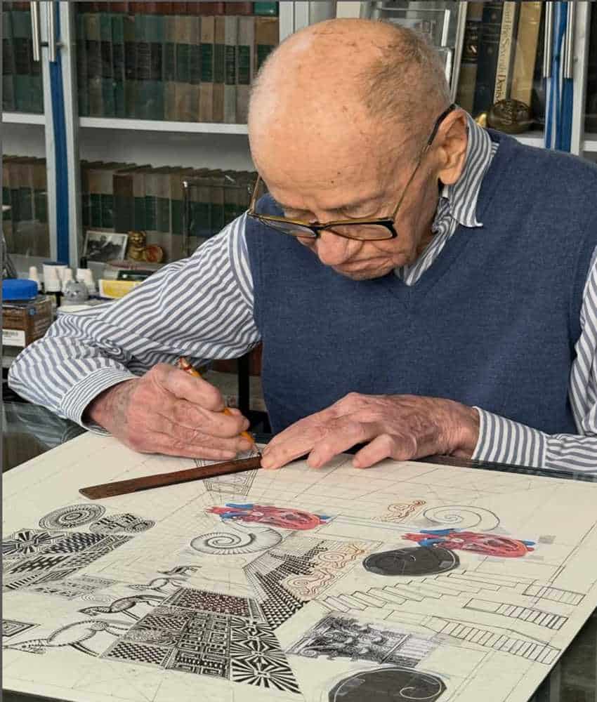 A close-up of artist Pedro Friedeberg working in his studio, using a ruler to sketch intricate geometric patterns and surrealist designs on a large sheet of drafting paper. Behind him is a large bookshelf with glass doors. It is feilled with old hardover books.