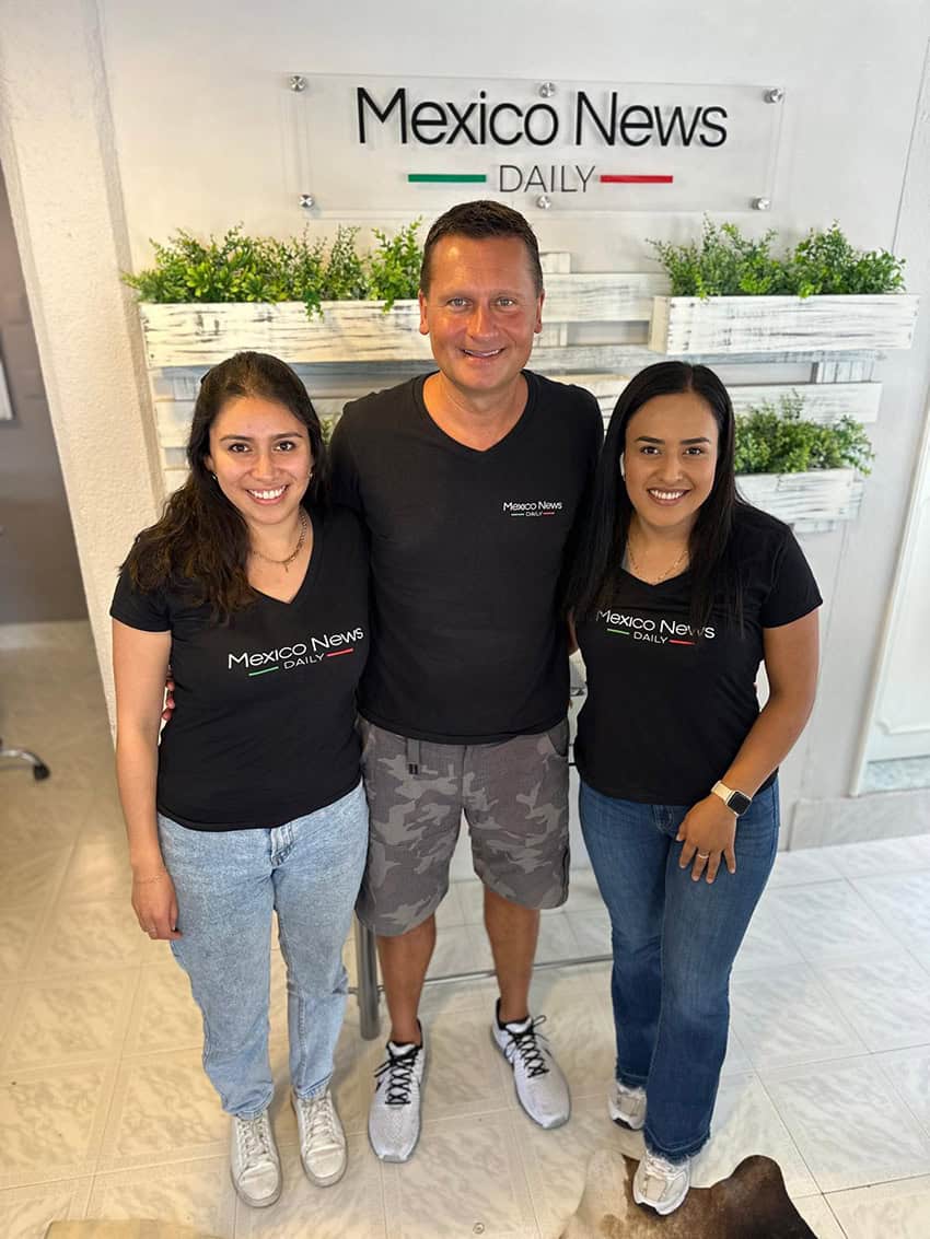 Three people pose wearing Mexico News Daily T-shirts